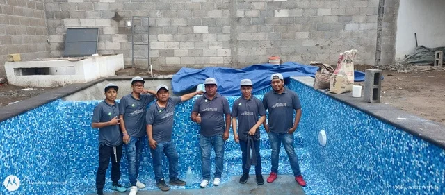Maestros de OneWave dentro de una alberca recién terminada con mosaico veneciano